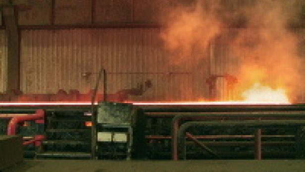 Glühendes Metall wird in einer Industrieanlage verarbeitet.