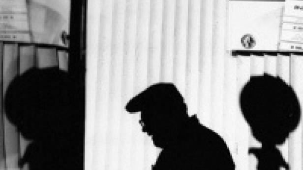 Die Silhouette eines Mannes mit Hut vor einem Fenster.