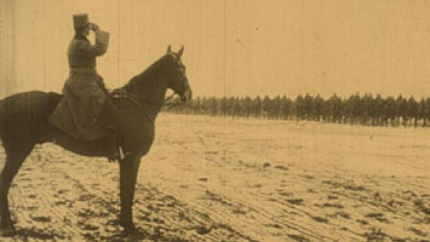 Ein Mann auf einem Pferd beobachtet eine lange Reihe von Soldaten in der Ferne.