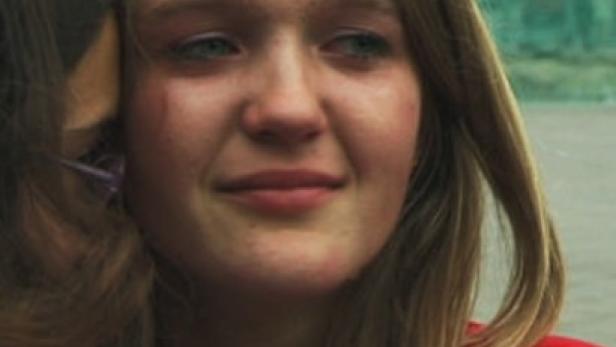 Eine junge Frau mit blonden Haaren weint, Tränen laufen ihr über das Gesicht.