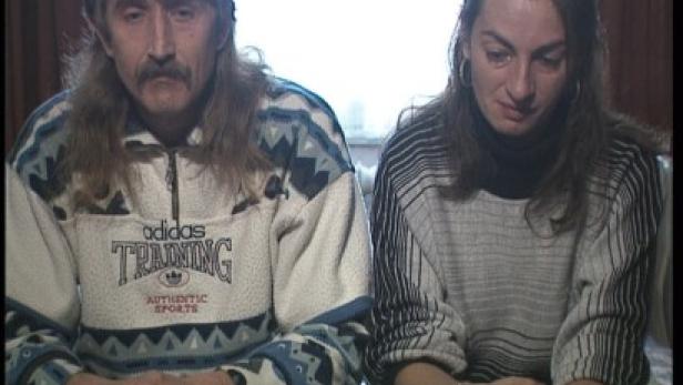 Ein Mann und eine Frau sitzen nebeneinander und wirken traurig.