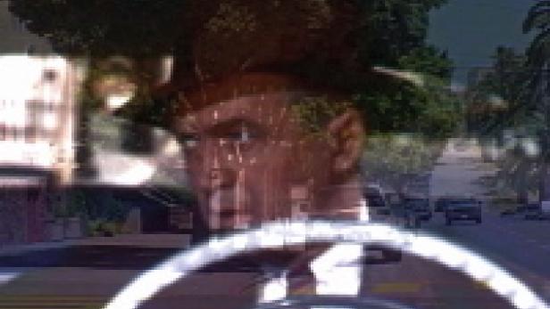 Ein Mann mit Hut fährt ein Auto auf einer sonnigen Straße.