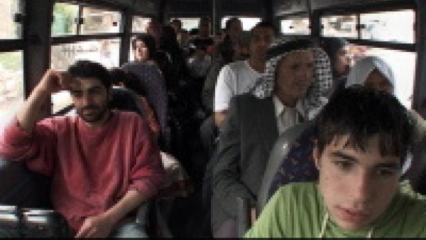 Menschen sitzen in einem Bus.