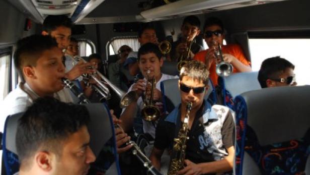 Eine Gruppe von Musikern spielt Blasinstrumente in einem Bus.
