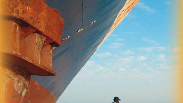 Das Filmplakat für „Hotel Sahara“ zeigt einen Mann vor einem großen Schiff.