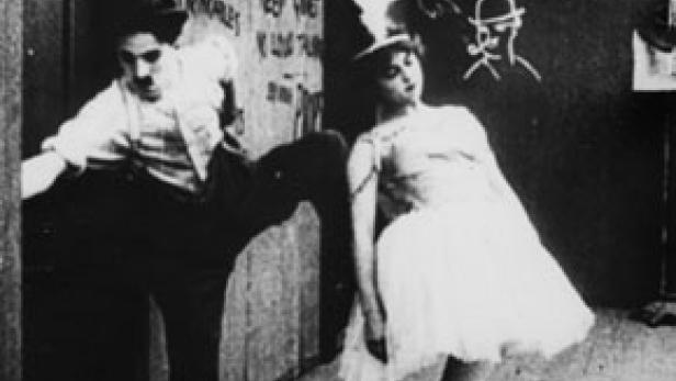 Charlie Chaplin und eine Ballerina in einer Szene aus einem Stummfilm.
