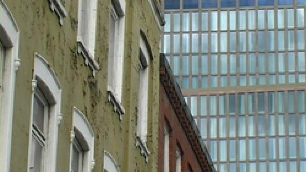 Mehrere Gebäude unterschiedlicher Bauart stehen nebeneinander.
