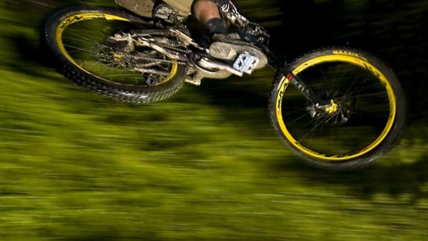 Ein Mountainbiker springt mit seinem Fahrrad über eine Rampe.