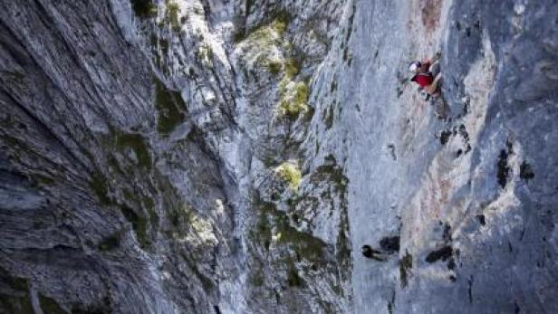Ein Kletterer erklimmt eine steile Felswand.