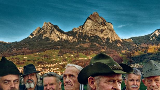 Das Filmplakat für „Wätter Schmöcker“ zeigt eine Gruppe älterer Männer vor einer Bergkulisse.