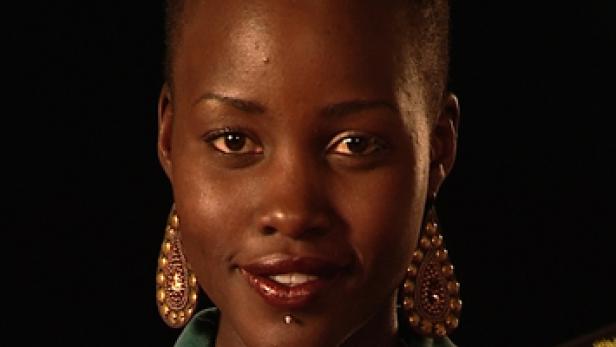 Nahaufnahme von Lupita Nyong'o mit goldenen Ohrringen und einem Piercing unter der Lippe.