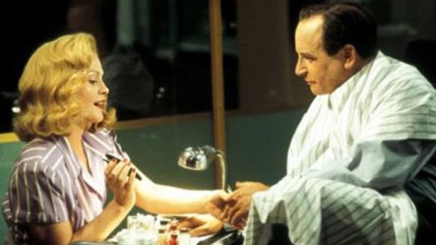 Eine Frau lackiert die Fingernägel eines Mannes.