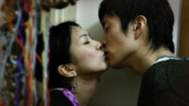 Ein asiatisches Paar küsst sich innig.