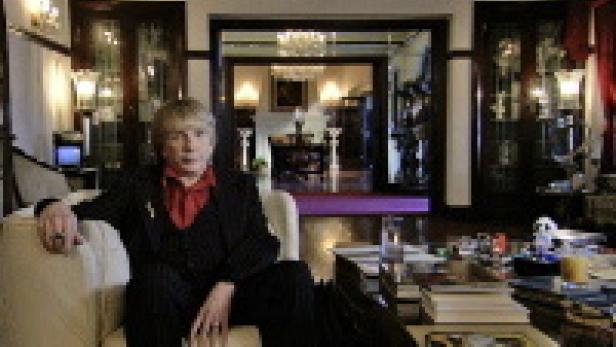 Eine Frau sitzt in einem eleganten Raum auf einem Sofa.
