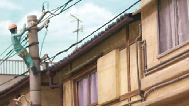 Ein Elektriker klettert auf einen Strommast in einer japanischen Stadt.