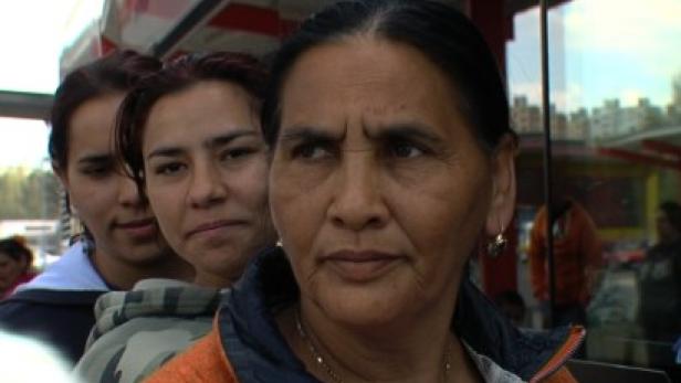 Eine ältere Frau mit zwei jüngeren Frauen im Hintergrund.