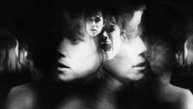 Ein Schwarz-Weiß-Foto zeigt mehrere überlagerte Gesichter mit ängstlichen Gesichtsausdrücken.