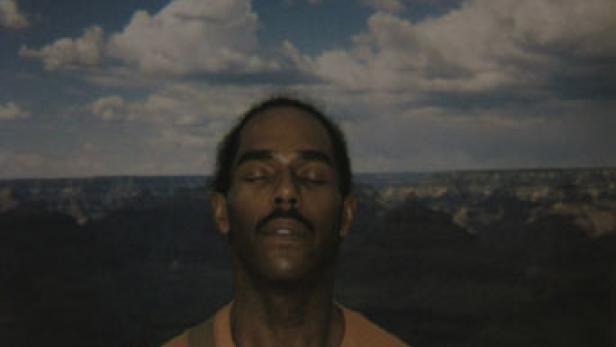Ein Mann meditiert vor dem Hintergrund des Grand Canyon.
