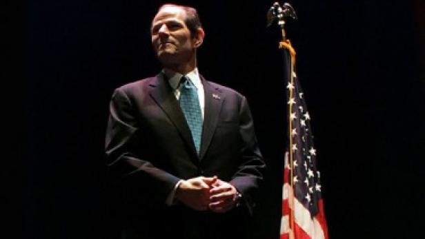 Eliot Spitzer steht vor einer US-Flagge.