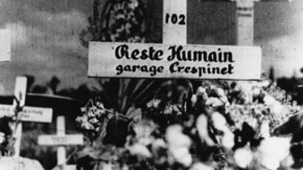 Ein Schild mit der Aufschrift „Reste Humain garage Crespinet“ auf einem Friedhof.