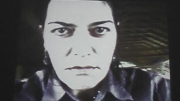 Eine Frau blickt ernst in die Kamera.