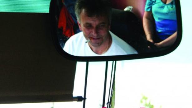 Das Filmplakat für „Gastarbajter“ zeigt einen Mann im Rückspiegel eines Busses.