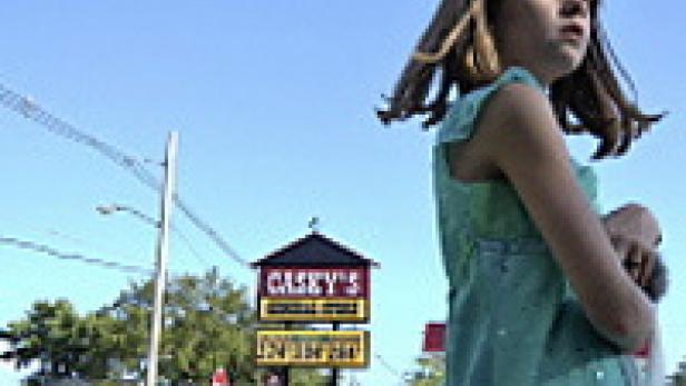 Ein junges Mädchen steht vor einem Casey's General Store.