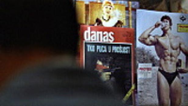 Ein Mann betrachtet eine Wand mit Zeitschriften und Postern.