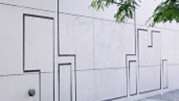 Eine weiße Wand mit einem abstrakten, dunklen Linienmuster.