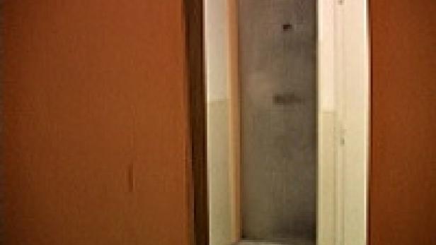 Eine graue Tür in einem orangefarbenen Flur.