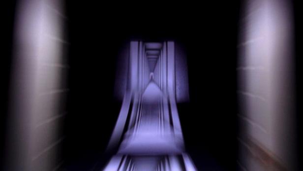 Ein langer, dunkler Korridor mit violettem Licht am Ende.