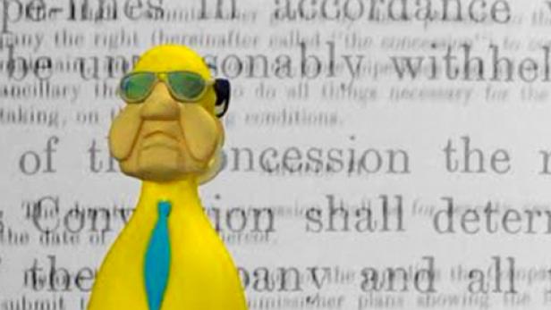 Eine gelbe Knetfiguren-Karikatur einer Person mit Sonnenbrille vor einem Textdokument.