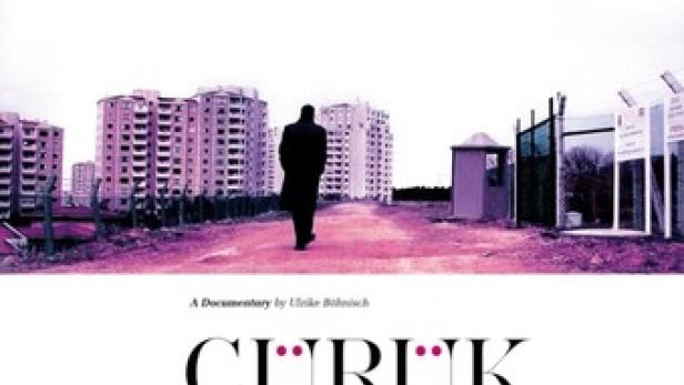 Ein Mann geht auf eine Reihe von Wohnblöcken zu, Szene aus dem Film „Çürük: The Pink Report“.