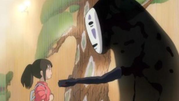Chihiro steht im Regen vor No-Face in einer Szene aus „Chihiros Reise ins Zauberland“.