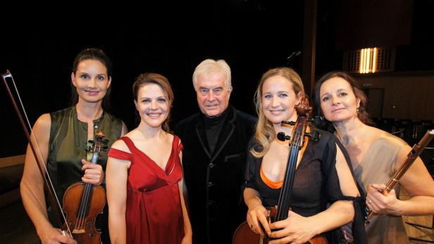 Fünf Musikerinnen und ein Dirigent posieren mit ihren Instrumenten.