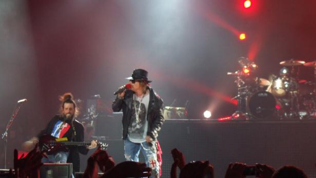 Axl Rose von Guns N' Roses singt auf der Bühne mit Slash im Hintergrund.