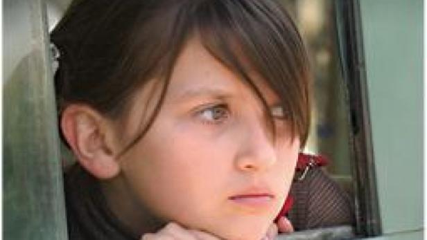 Das Filmplakat für „En el nombre de la hija“ zeigt ein Mädchen, das aus einem Fenster schaut.