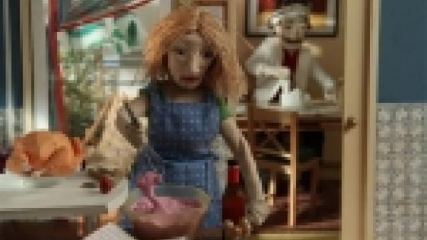 Eine Stop-Motion-Puppe in einer Küche mit einem rosa Objekt in einer Schüssel.