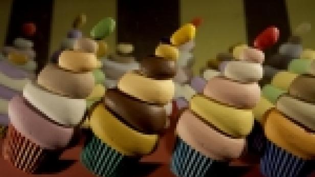 Mehrere bunte Cupcakes stehen nebeneinander.