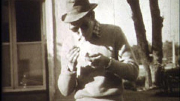 Ein Mann mit Hut und Sonnenbrille dreht sich eine Zigarette.