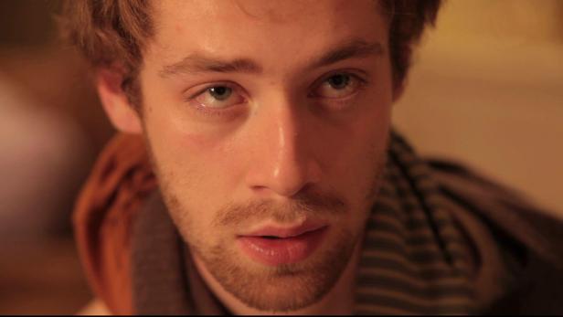 Ein junger Mann mit Bart schaut in die Kamera.