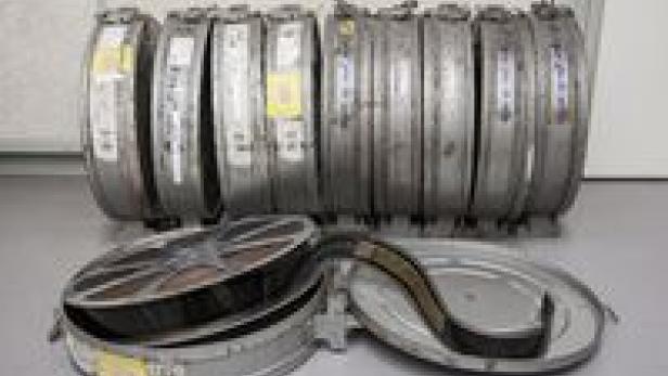 Mehrere Filmrollen stehen in silbernen Dosen.