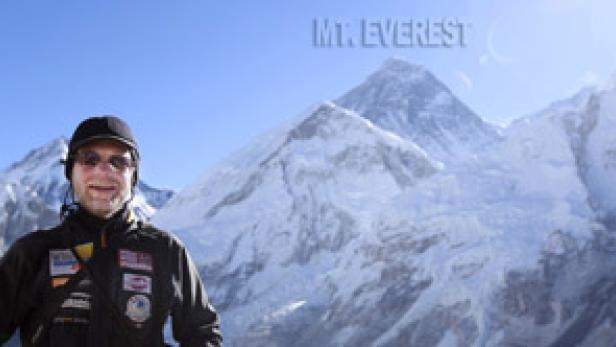 Ein Mann steht vor dem Mount Everest.