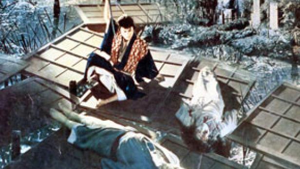 Ein Samurai steht mit einem Schwert auf einem Dach, umgeben von zwei toten Körpern.