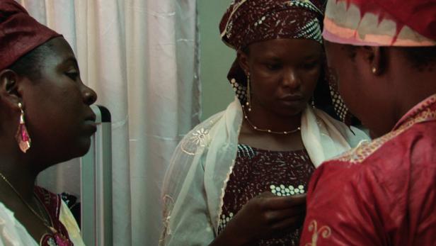 Drei Frauen mit traditioneller afrikanischer Kleidung stehen zusammen.