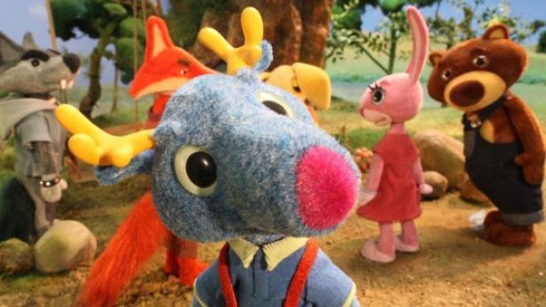 Puppen verschiedener Tiere stehen in einer Waldkulisse.