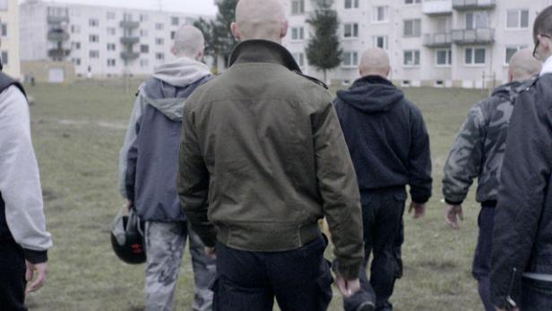 Eine Gruppe von Männern geht in Richtung einer Wohnsiedlung.