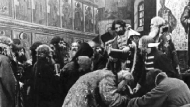 Eine Gruppe orthodoxer Priester in einer Kirche mit Wandmalereien.