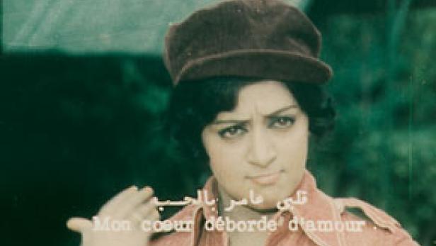 Eine Frau mit dunklen Haaren und einer braunen Kappe blickt in die Kamera.