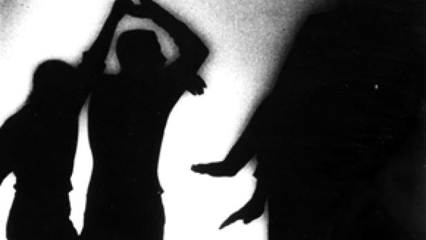 Die Schattenrisse von drei Personen vor einer hellen Wand.